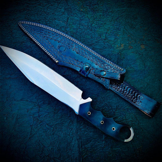 A handmade full tang construction Bowie knife with a stainless steel blade and black micarta handle, accompanied by a leather sheath with embossed patterns.