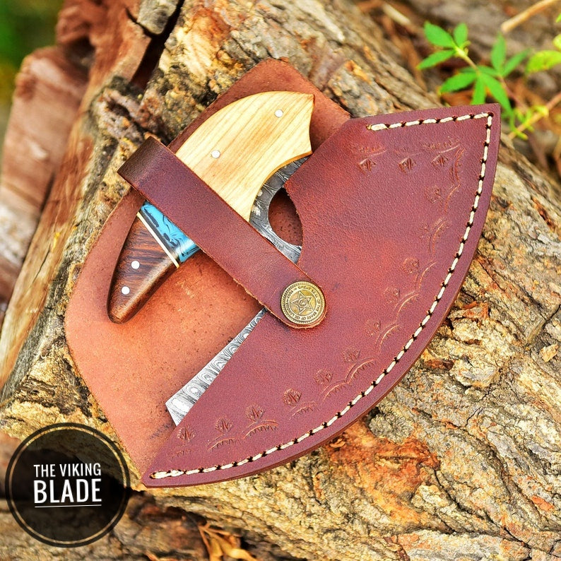 Hand forged curved Ulu knife showing detailed blade pattern and Celtic knot handle design