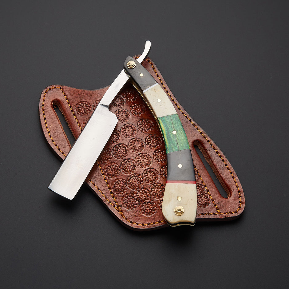 A straight razor with a multi-colored bone handle and a silver blade, resting on its brown embossed leather sheath against a dark gray background.