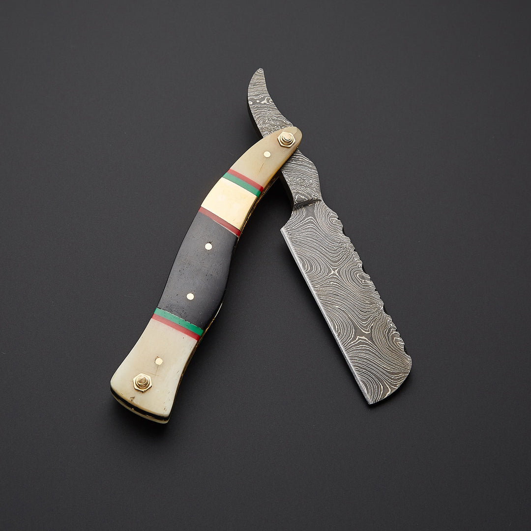 handmade Damascus steel straight razor blade showing detailed wave pattern and ultra-sharp cutting edge.