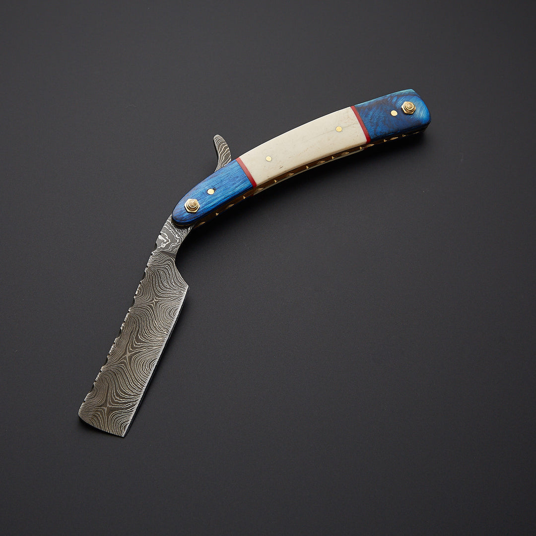Close-up of Damascus steel straight razor blade showing detailed wave pattern and razor-sharp edge for precision shaving.