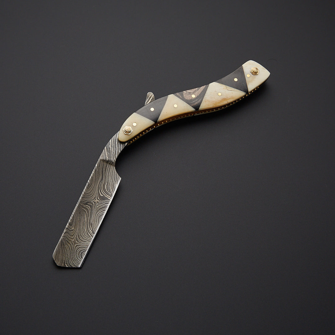 Damascus steel straight razor blade showing unique wave pattern and precision-sharpened edge for smooth shaving.