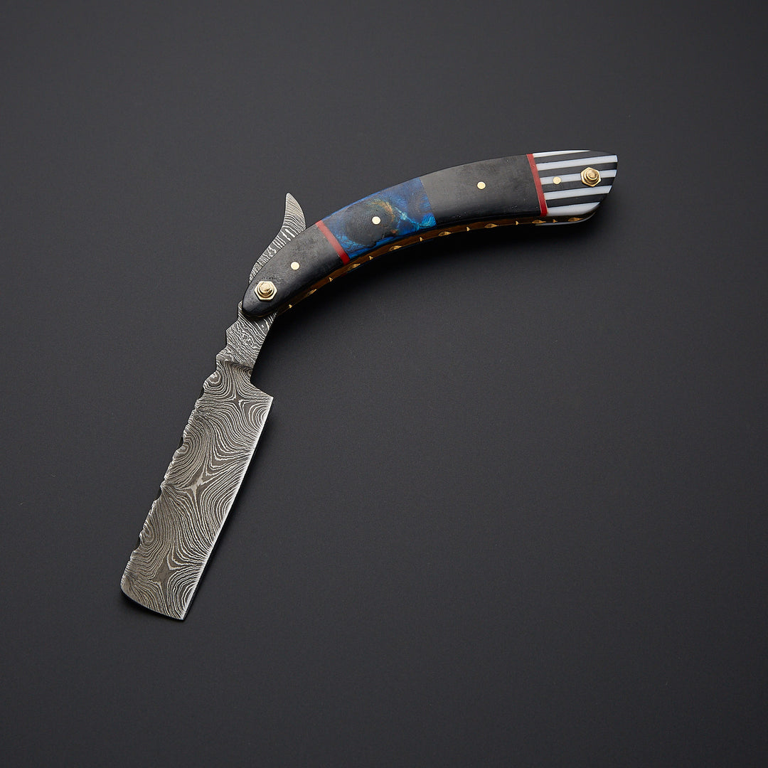 Classic folding cut throat barber razor displayed in open position highlighting traditional craftsmanship and metal detailing.