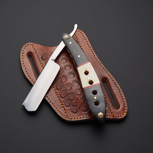 A straight razor with a dark handle and silver blade, resting on a brown embossed leather sheath against a dark gray background.