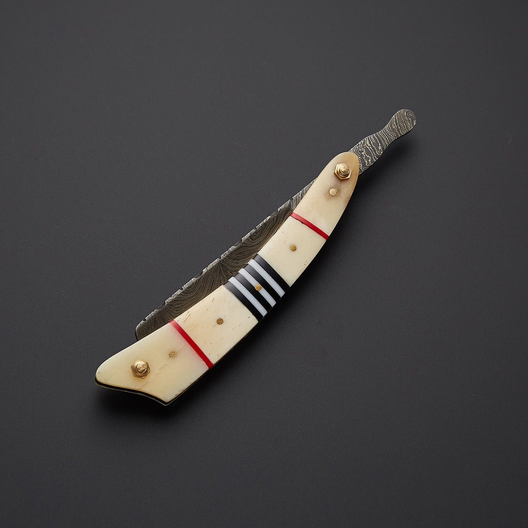 Traditional barber straight razor shown in open and closed positions highlighting folding design and handcrafted metal work.